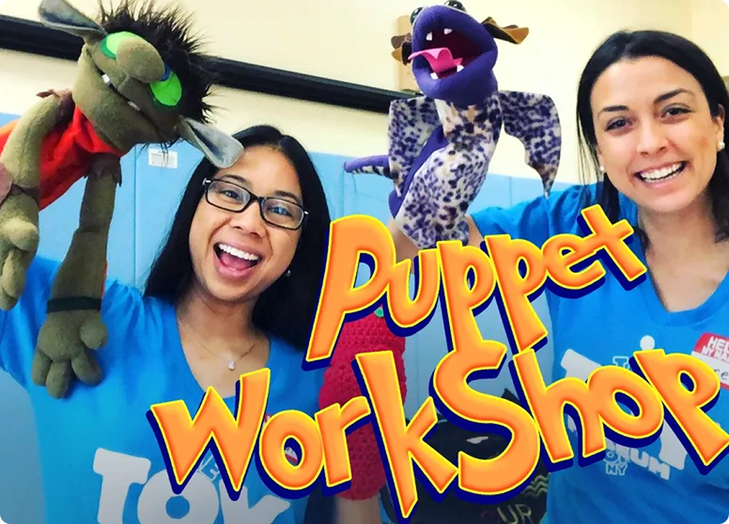 Two women holding puppets at workshop.