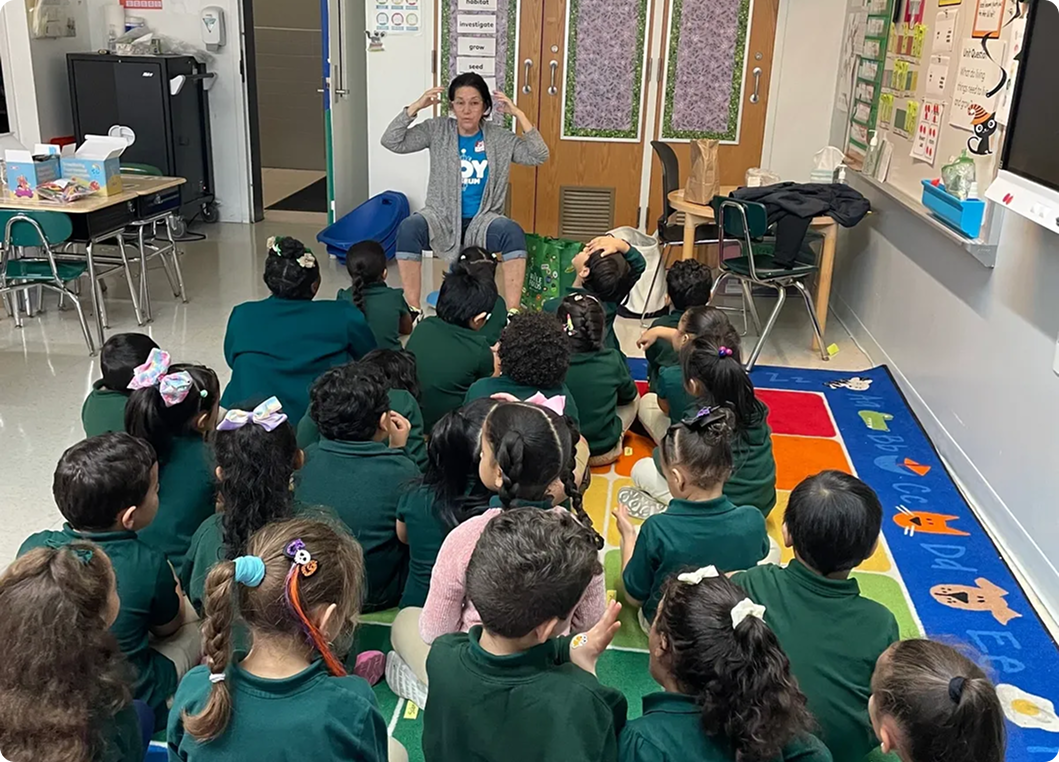 Teacher reading to attentive young students.