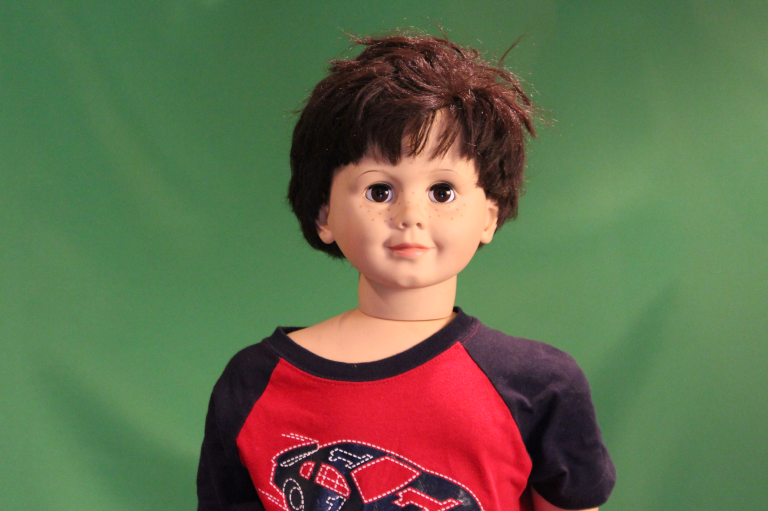 Childlike doll wearing a colorful shirt.