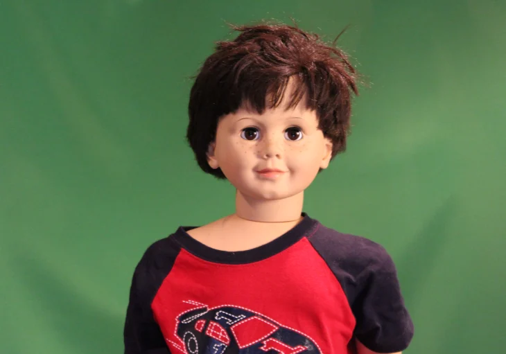 Childlike doll wearing a colorful shirt.